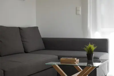 a living room with a couch and a glass table at Varkiza Seaside Apartment in Vari