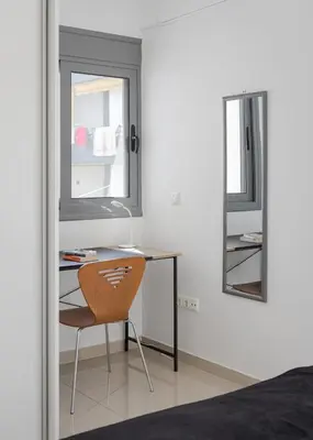 a bedroom with a desk and a chair and a mirror at Varkiza Seaside Apartment in Vari
