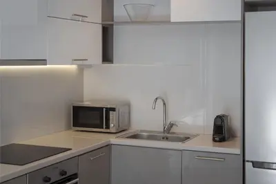 a kitchen with a sink and a microwave at Varkiza Seaside Apartment in Vari