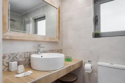 a bathroom with a sink and a mirror at Varkiza Seaside Apartment in Vari