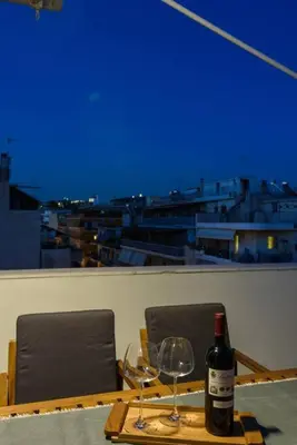 a table with a bottle of wine and two glasses at Elektra Suite in Athens