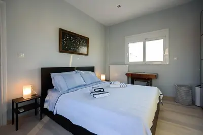 a bedroom with a large white bed and two lamps at Elektra Suite in Athens