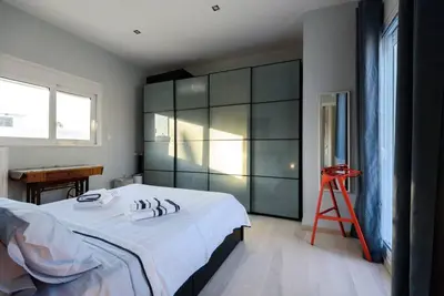 a bedroom with a large white bed and a red stool at Elektra Suite in Athens