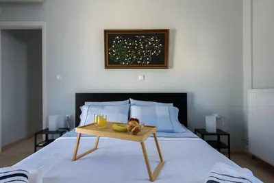 a bed with a table with fruit and two glasses on it at Elektra Suite in Athens