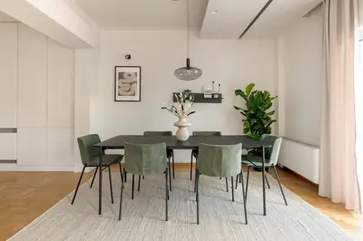 a dining room with a black table and green chairs at Luminous 3BR Apartment in Cholargos by UPSTREET in Athens