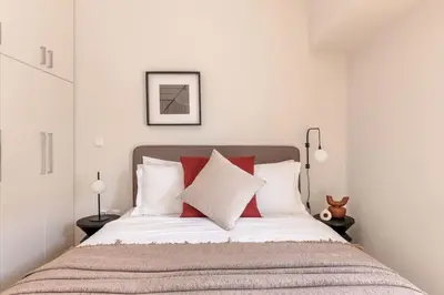 a bedroom with a bed with red and white pillows at Luminous 3BR Apartment in Cholargos by UPSTREET in Athens