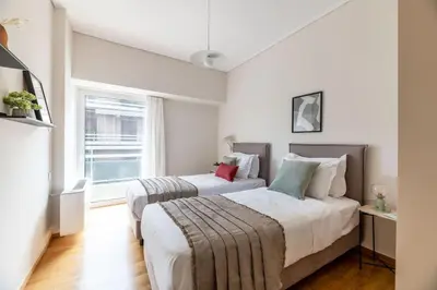 a bedroom with two beds and a window at Luminous 3BR Apartment in Cholargos by UPSTREET in Athens