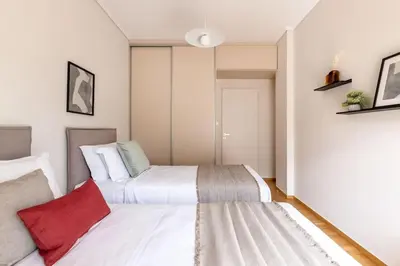 a bedroom with two beds with white sheets and red pillows at Luminous 3BR Apartment in Cholargos by UPSTREET in Athens