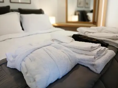 a pile of white towels sitting on top of a bed at Aelia Luxury Properties - Executive Apartment in Athens