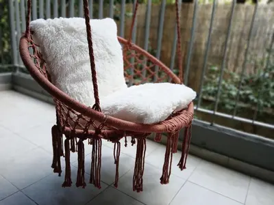 a wicker swing chair sitting on a porch at Aelia Luxury Properties - Executive Apartment in Athens