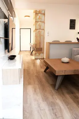 a kitchen and living room with a wooden table at Aelia Luxury Properties - Executive Apartment in Athens
