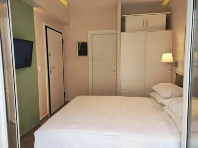 a small bedroom with a white bed and a television at Athens Stay 15 in Athens