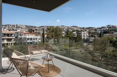 a balcony with chairs and a table and a large window at Athenian Riviera Elegant Residence in Athens