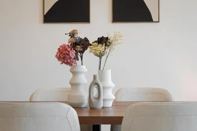 three white vases sitting on a wooden table with chairs at Athenian Riviera Elegant Residence in Athens