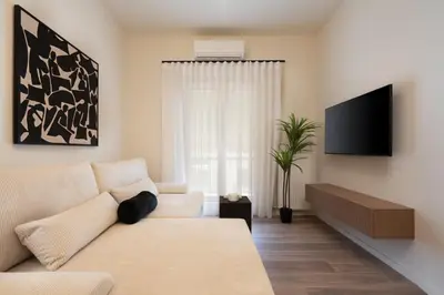 a living room with a couch and a tv at Athens City Modern Apartments in Athens