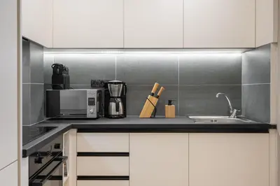 a kitchen counter with a microwave and a sink at Athens City Modern Apartments in Athens