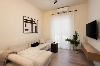 a white living room with a couch and a tv at Athens City Modern Apartments in Athens