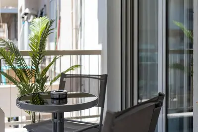 a table and chairs on a balcony with a window at Athens City Modern Apartments in Athens