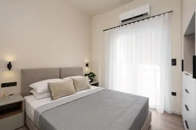 a white bedroom with a large bed and a window at Athens City Modern Apartments in Athens