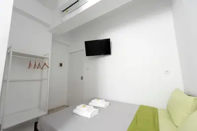 a white room with a bed with a tv on the wall at Ati-Key Residence in Athens