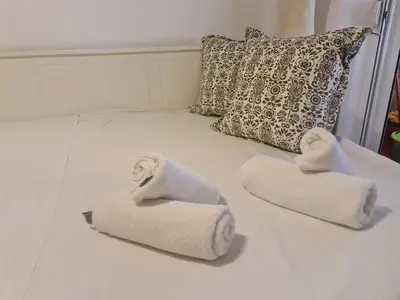 a white bed with towels on it with a pillow at Cute Apartment Next To Acropolis Museum in Athens