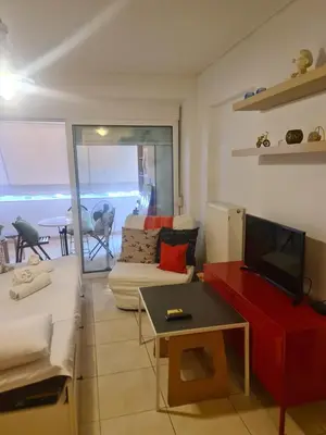 a living room with a couch and a tv and a table at Cute Apartment Next To Acropolis Museum in Athens