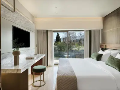a bedroom with a large bed and a desk and a television at Anthology of Athens, The Leading Hotels of the World in Athens
