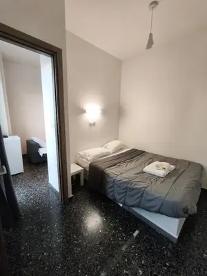 a small bedroom with a bed and a mirror at Liberal Mini Rooms & Suites in Athens