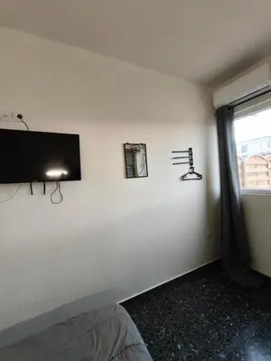 a room with a tv on a wall with a window at Liberal Mini Rooms & Suites in Athens
