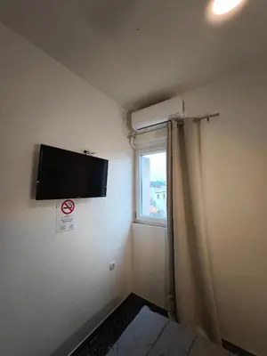a room with a flat screen tv on the wall at Liberal Mini Rooms & Suites in Athens
