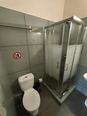 a bathroom with a toilet and a shower at Liberal Mini Rooms & Suites in Athens