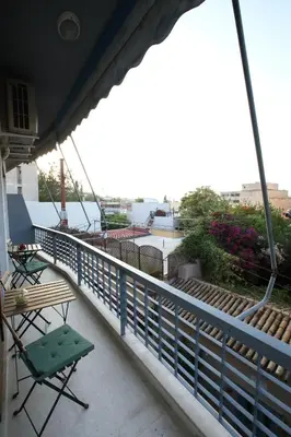 a balcony with a green chair and an umbrella at Modern 2BD apartment next to Acropolis in Athens