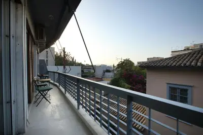 a balcony with a green chair on a building at Modern 2BD apartment next to Acropolis in Athens