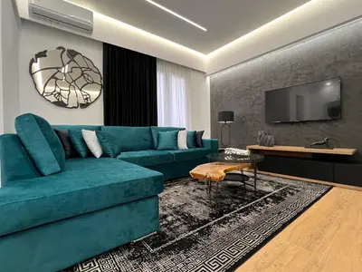 a living room with a blue couch and a tv at Acropolis Signature Apartment in Athens
