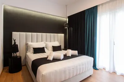 a bedroom with a large white bed with pillows at Acropolis Signature Apartment in Athens