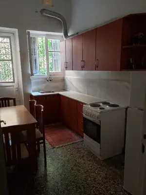 a kitchen with a stove and a sink and a table at Relax & Enjoy in Athens