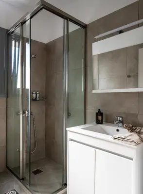 a bathroom with a shower and a sink at Athenian Songs - 3BR Penthouse with Acropolis Views in Athens