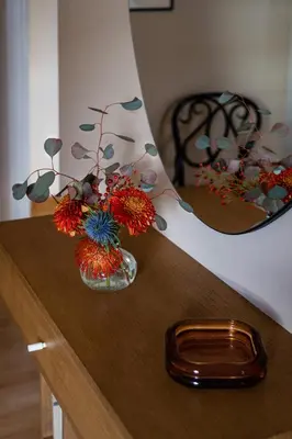 a vase of flowers sitting on a wooden table at Athenian Songs - 3BR Penthouse with Acropolis Views in Athens