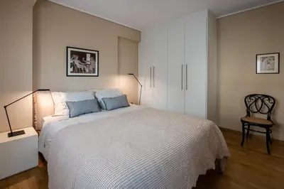 a bedroom with a large white bed with blue pillows at Athenian Songs - 3BR Penthouse with Acropolis Views in Athens
