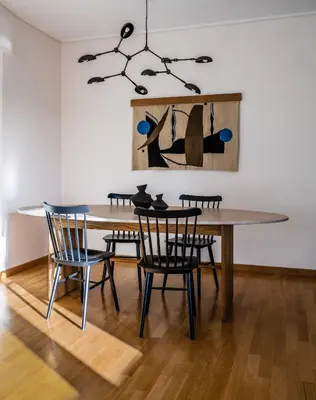 a dining room table with chairs and a painting on the wall at Athenian Songs - 3BR Penthouse with Acropolis Views in Athens