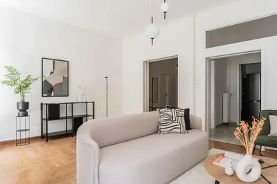 a white living room with a couch and a table at Acropolis Sunlight 2BR Apartment by UPSTREET in Athens