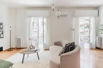a white living room with a couch and a table at Acropolis Sunlight 2BR Apartment by UPSTREET in Athens