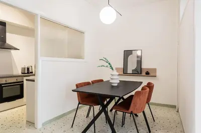 a dining room with a black table and chairs at Acropolis Sunlight 2BR Apartment by UPSTREET in Athens