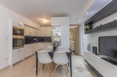 a kitchen with a table and chairs and a tv at Varkiza Seaside 2BD Apartment in Varkiza