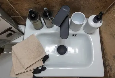 a white sink with a knife and cups on it at Callista apartment in Athens