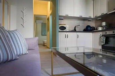 a kitchen with a couch and a glass counter top at Callista apartment in Athens