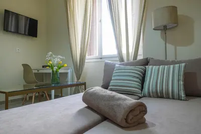 a bedroom with a bed with a couch and a table at Callista apartment in Athens