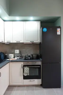 a kitchen with a black refrigerator and white cabinets at Callista apartment in Athens