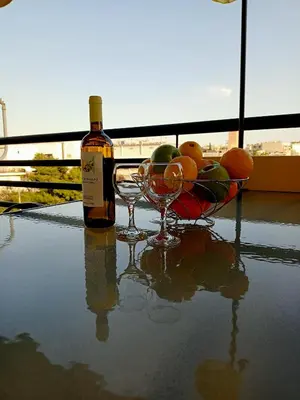 a bottle of wine and two wine glasses on a table at Myilios Leisure Piraeus by Ilios Company in Piraeus