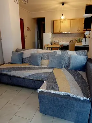 a living room with a couch and a kitchen at Myilios Leisure Piraeus by Ilios Company in Piraeus